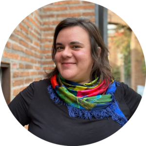 Leonor Merín posando frente a la cámara, con polera negra y una bufanda de colores fuertes.