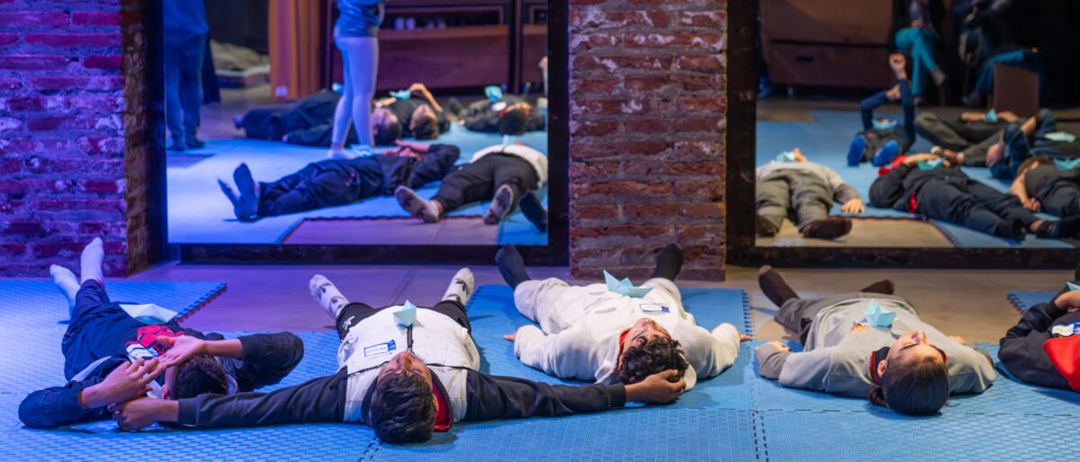 Un grupo de niños y niñas se prepara para meditar en el aula del espacio KAOS
