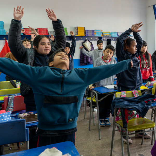 En la educación moderna, donde los resultados académicos suelen dominar la conversación, nos preguntamos cómo formar estudiantes plenos que desarrollen su intelecto, pero también su bienestar emocional, físico y espiritual. La respuesta puede encontrarse en el poder del juego. Cuando diseñamos actividades lúdicas con intención pedagógica, creamos puentes naturales entre las cuatro dimensiones del ser. Estos cinco juegos probados en aulas innovadoras ofrecen las herramientas para construir esos puentes. 1. El Termómetro emocional, para medir lo invisible y hacerlo visible Cada mañana, al entrar al aula, los estudiantes encuentran un gran termómetro dibujado en la pizarra con cuatro zonas de colores: azul (tranquilo), verde (equilibrado), amarillo (agitado) y rojo (intenso). Con pegatinas con sus nombres, marcan su estado emocional actual. Los estudiantes que lo deseen pueden compartir brevemente qué "temperatura emocional" traen hoy y por qué. La magia ocurre cuando, tras una clase con actividades físicas o artísticas, volvemos al termómetro y observamos cómo han cambiado las posiciones. Este juego simple pero poderoso enseña que las emociones son dinámicas, válidas y manejables, integrando la dimensión emocional con la conciencia corporal, al notar los cambios físicos que acompañan cada estado. 2. Carrera de obstáculos matemática, dándole vida a los números Imaginemos un circuito en el patio, donde cada estación representa un problema matemático. Los estudiantes, en equipos, deben saltar, gatear o correr hasta cada punto, resolver el ejercicio (que puede estar relacionado con el tema que están viendo), y solo al acertar pueden avanzar. Pero hay un giro: en la última estación, encuentran una pregunta reflexiva como "¿Cómo te sentiste al equivocarte?" o "¿Qué estrategia mental y física usaste para resolverlo?". Aquí, el cuerpo se activa, la mente se enfoca, las emociones fluyen con la competencia sana, y el alma se nutre al reconocer el proceso de aprendizaje como un todo. 3. Mandala grupal, pintando conexiones visibles e invisibles Este juego comienza con una búsqueda: los estudiantes recolectan objetos naturales durante un paseo (hojas, piedras, ramas) o usan materiales del aula (lápices, borradores, papeles de colores). En círculo, van construyendo juntos un mandala en el suelo, alternando turnos para añadir elementos mientras comparten qué representa su aporte para ellos ("esta piedra lisa es como mi mente cuando entiendo un concepto difícil"). La dimensión espiritual emerge al reflexionar sobre cómo cada pieza, como cada persona, es única pero parte de un todo armonioso. El cuerpo participa en los movimientos conscientes al colocar los objetos, la mente en el diseño geométrico, y las emociones al expresar sus significados personales. Al final, fotografían su creación efímera como metáfora de lo transitorio y valioso del aprendizaje colaborativo. 4. El Juego del espejo, para reconocerse en el otro En parejas, un estudiante guía con movimientos lentos (como levantar un brazo, girar, saltar) mientras el otro debe reflejarlo como un espejo perfecto. Después de dos minutos, intercambian roles. La segunda fase agrega complejidad: ahora el "espejo" debe adivinar qué emoción está expresando el guía (alegría, sorpresa, enojo contenido) solo a través de los movimientos corporales. Este juego desarrolla la empatía kinestésica, esa capacidad de leer las emociones a través del lenguaje corporal. La reflexión posterior guiada por el profesor conecta con cómo nuestras posturas afectan nuestro estado mental (dimensión mente-cuerpo), cómo interpretamos a otros (dimensión emocional), y qué significa realmente "ponerse en los zapatos del otro" (dimensión espiritual). Es especialmente útil para resolver conflictos en el aula. 5. Cartas de valores, poniendo la ética en juego El profesor prepara un mazo de cartas con valores como "respeto", "curiosidad", "perseverancia" o "compasión". Cada estudiante saca una carta al azar al comenzar la semana. Su misión es encontrar tres momentos donde puedan aplicar ese valor, ya sea en lo académico ("fui curioso al hacer preguntas en ciencia"), lo social ("mostré compasión cuando un compañero estaba triste") o lo personal ("fui perseverante al practicar piano"). El viernes, comparten sus experiencias en círculo. Hasta el momento acá solo hemos integrado una de las dimensiones, emoción, ¿pero cómo podemos hacerlo más completo? Le pedimos a los estudiantes representar uno de esos momentos a través de la mímica, mientras los demás adivinan qué valor y situación están mostrando. Este juego multidimensión cultiva la autoconciencia (alma), la expresión corporal (cuerpo), la inteligencia emocional (al reconocer valores en acción) y el pensamiento crítico (mente al analizar situaciones). ¿Por qué son juegos transformadores para integrar? Estos juegos comparten tres características transformadoras: son inclusivos (permiten múltiples formas de participación), reflexivos (siempre incluyen un momento de metacognición), y holísticos (nunca trabajan una dimensión aislada). La verdadera innovación educativa no está en la tecnología, sino en redescubrir el juego como puente entre lo que somos y lo que aprendemos. Como decía María Montessori: “El niño que tiene libertad y oportunidad de manipular y usar su mano en una forma lógica, con consecuencias y usando elementos reales, desarrolla una fuerte personalidad".